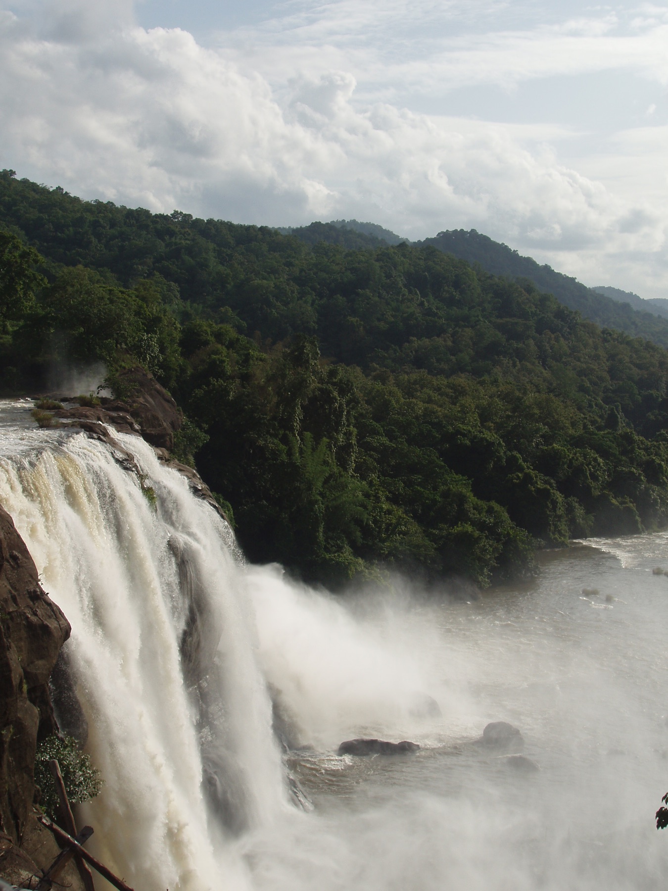 Athirappilly waterfall flowing through a broad forested river landscape